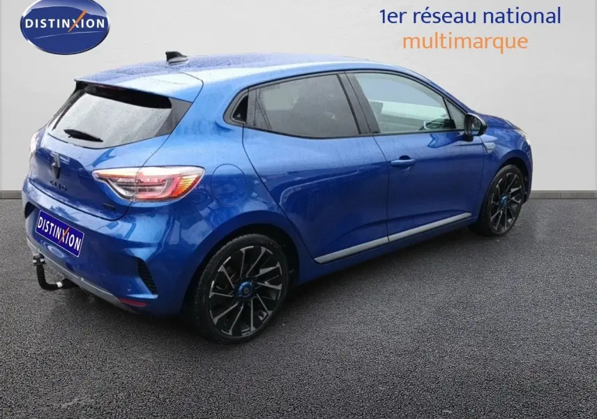 Renault Clio 1.6 E-Tech hybride bleu Iron Metal vue 3/4 arrière côté droit avec jantes noires distinctives.
