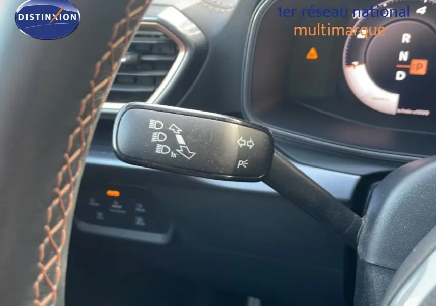 Gros plan sur la manette de clignotant à gauche du volant dans l’habitacle noir du CUPRA Formentor blanc neige 2025.