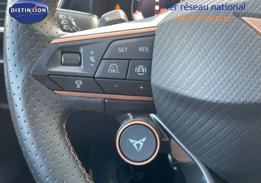Gros plan sur le volant cuir perforé noir du CUPRA Formentor 2.0 TDI 150ch avec commandes intégrées et logo distinctif.