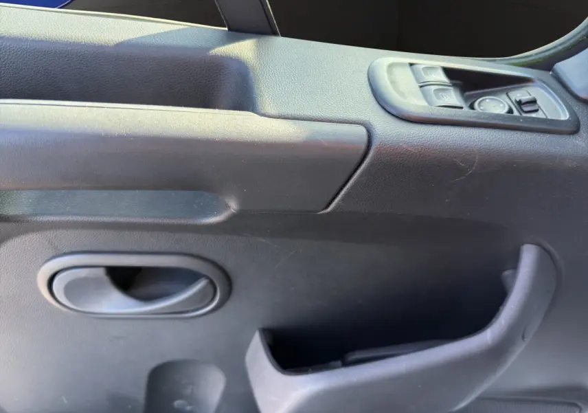 Détail de la porte intérieure côté conducteur du Nissan Interstar 2024, avec commandes électriques et poignée noire.