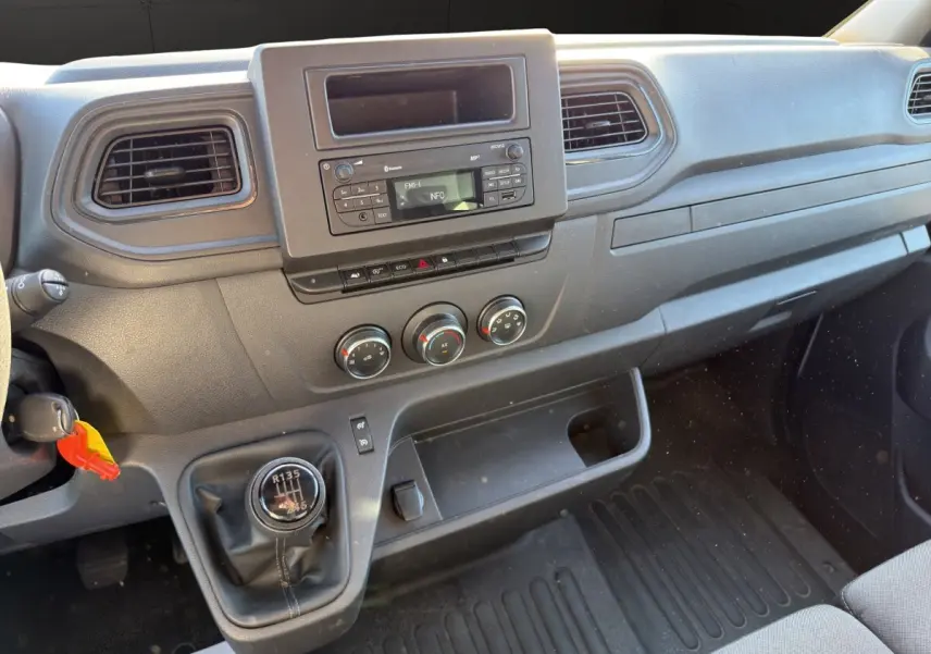 Vue intérieure du tableau de bord du Nissan Interstar 2024 avec boîte manuelle et commandes centrales noires.
