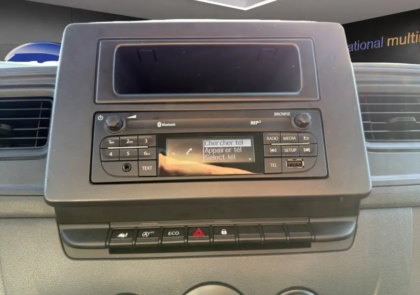Vue rapprochée du tableau de bord noir du Nissan Interstar 2024, avec système audio et commandes visibles.