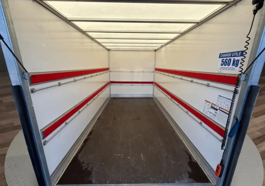 Vue intérieure de la caisse blanche du Nissan Interstar avec bandes rouges et panneau indiquant charge utile 560 kg.