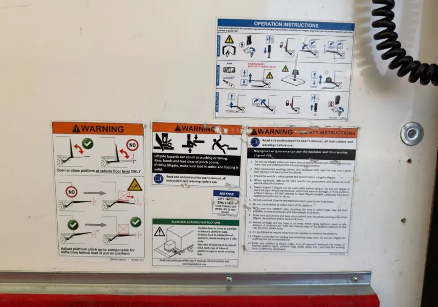 Détail des consignes de sécurité sur la porte arrière blanche du Nissan Interstar 2024, vue rapprochée.