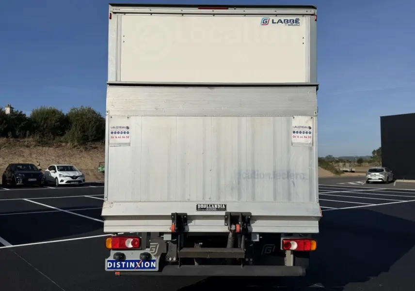 Vue arrière d’un utilitaire blanc Nissan Interstar avec hayon élévateur et marquages LABBE sur caisse.