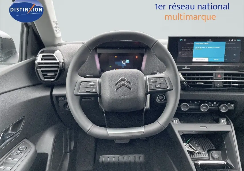 Vue intérieure centrée sur le volant multifonction et le tableau de bord numérique d'une Citroën C4 2024.