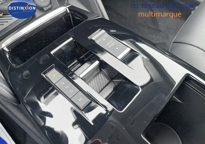 Gros plan sur la console centrale noire brillante de la Citroën C4 2024, mettant en valeur la commande de boîte automatique et le bouton Drive Mode.