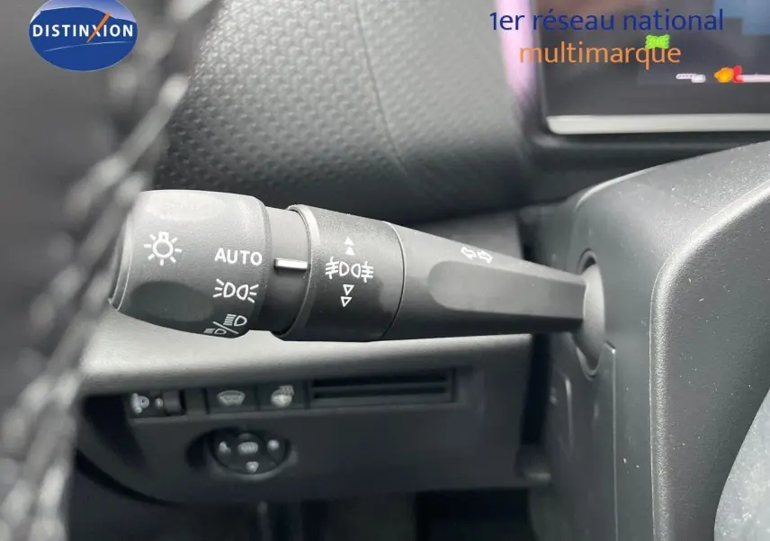 Gros plan sur la commande des phares et clignotants à gauche du volant dans une Citroën C4 blanche métal 2024.