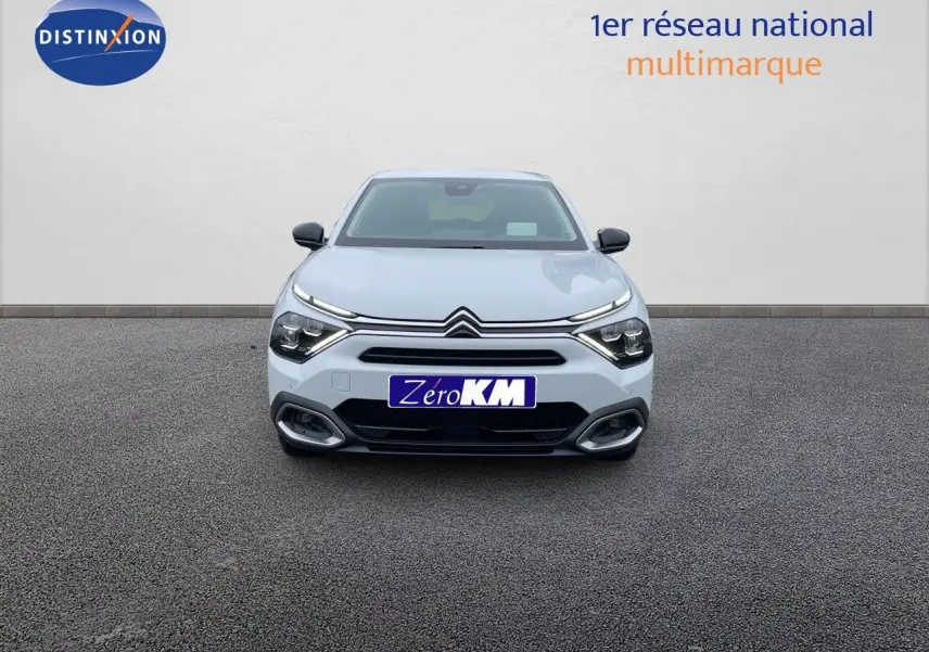 Vue frontale d'une Citroën C4 blanche métal 2024 avec feux LED et calandre distinctive sur fond neutre.