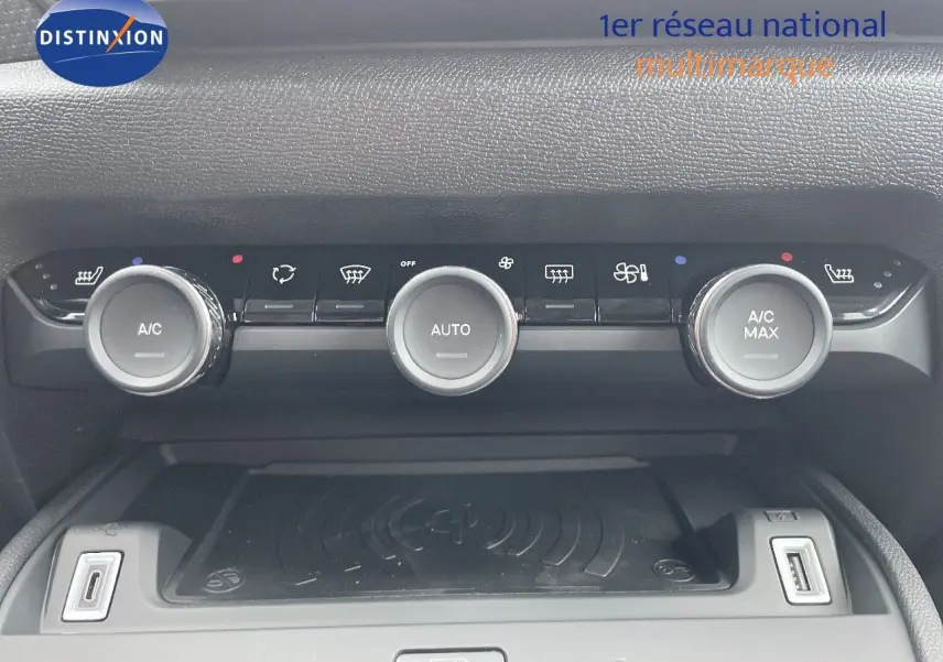 Vue rapprochée de la console centrale de la Citroën C4 blanche, montrant les commandes de climatisation et ports USB.