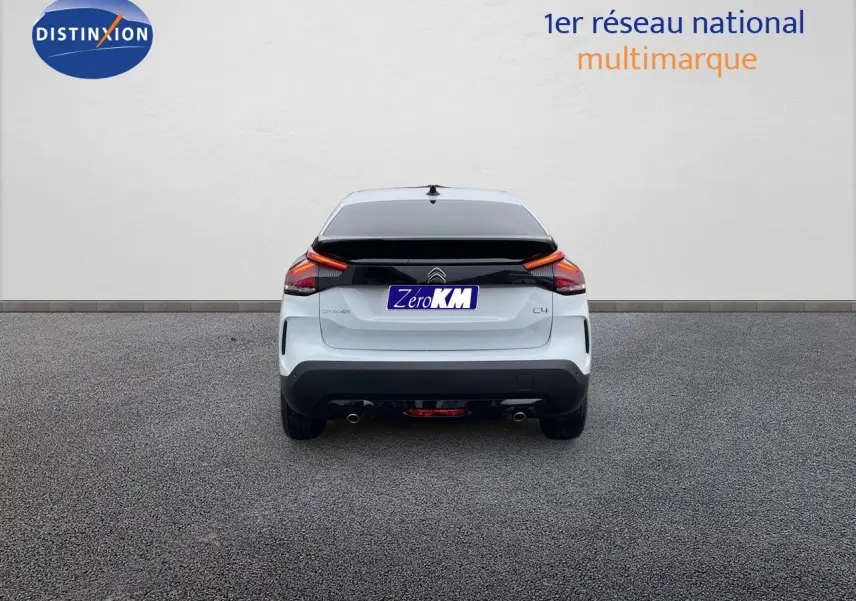 Vue arrière d'une Citroën C4 blanche métal 2024 avec feux LED et double sortie d'échappement visible.