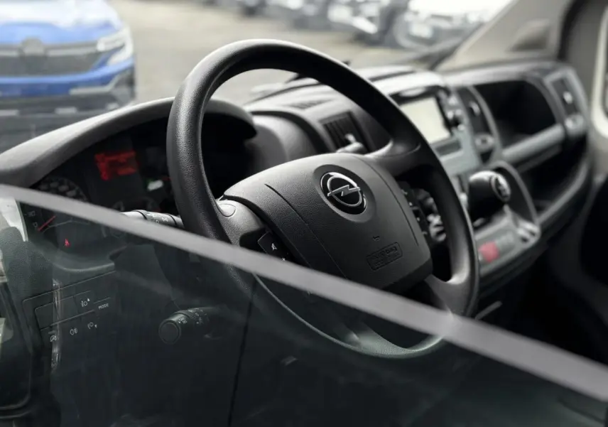 Vue intérieure rapprochée du volant Opel Movano Fourgon 2023, avec tableau de bord et commandes visibles.