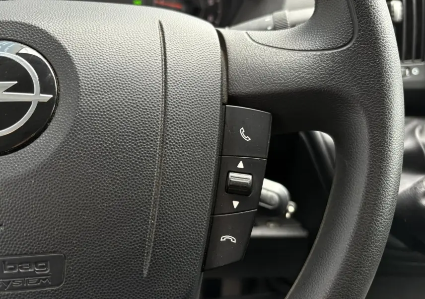 Gros plan sur le volant noir de l'Opel Movano Fourgon 2023 avec commandes d'appel intégrées.