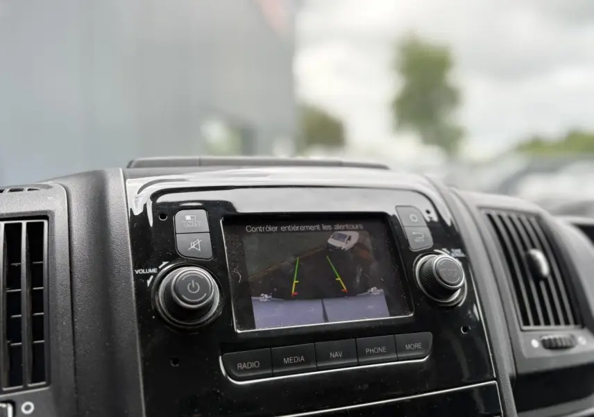 Écran tactile central affichant la caméra de recul du tableau de bord noir de l'Opel Movano Fourgon blanc 2023.