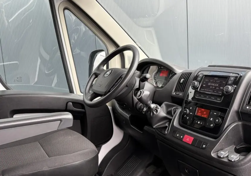 Vue intérieure côté conducteur de l'Opel Movano Fourgon blanc 2023, avec tableau de bord et volant visibles.