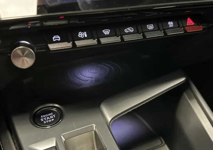 Gros plan sur la console centrale intérieure de la Peugeot 308 SW gris, avec bouton start/stop et commandes climatisation.