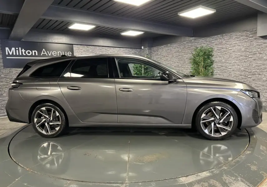 Peugeot 308 SW gris métallisé vue de profil côté gauche, jantes alliage 17 pouces et vitres surteintées.