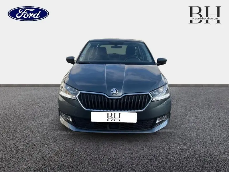 Vue de face d'une Skoda Fabia gris météore 2021 avec calandre noire et phares halogènes allumés.