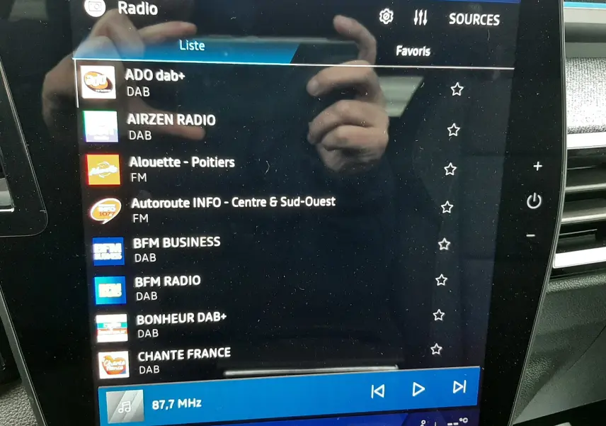 Écran tactile central du Renault Austral Ph.2 gris schiste, affichant la liste des radios DAB et FM, intérieur moderne.
