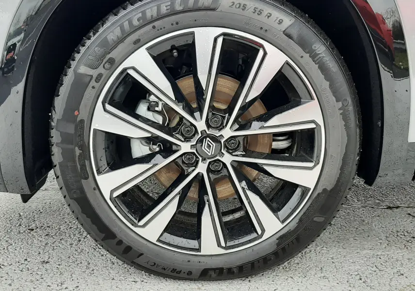 Gros plan sur la roue avant droite du Renault Austral Ph.2 gris schiste, avec jante alliage bicolore et pneu Michelin.