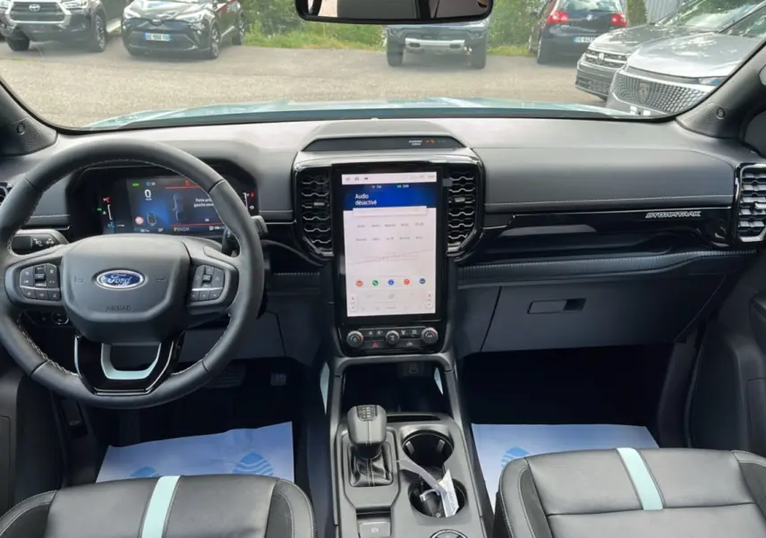 Vue intérieure avant du Ford Ranger Stormtrak 2026 avec tableau de bord noir et écran tactile vertical central.
