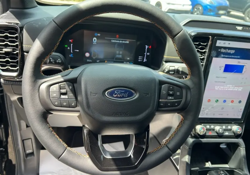 Vue intérieure centrée sur le volant cuir noir avec coutures jaunes du Ford Ranger 2.3 PHEV Wildtrak Plus 2026.
