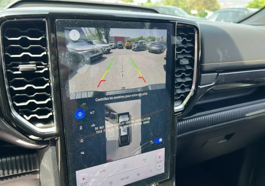 Vue intérieure centrée sur l'écran tactile du Ford Ranger noir agate montrant la caméra de recul et le tableau de bord.