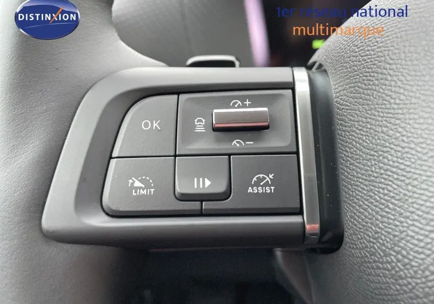 Gros plan sur les commandes du volant de la Citroën C4 2024 gris platinium, avec boutons de régulateur et assistant de conduite.