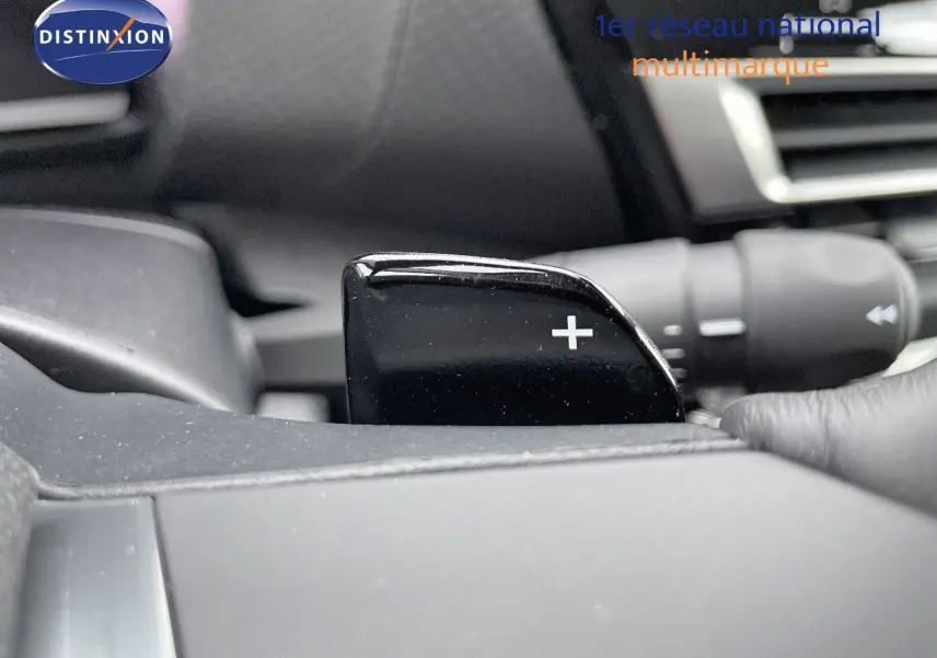 Gros plan sur la palette de changement de vitesse "+" côté droit du volant dans l'habitacle gris d'une Citroën C4 2024.