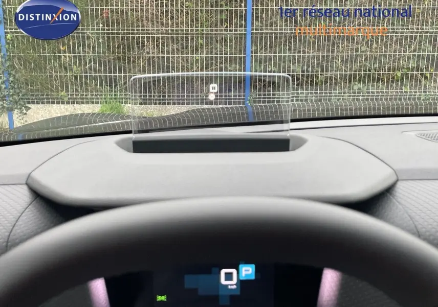 Vue depuis le poste de conduite d'une Citroën C4 gris platinium, avec affichage tête haute et volant en premier plan.