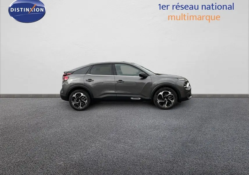 Profil côté gauche d'une Citroën C4 2024 gris platinium métal avec jantes noires et toit noir contrasté.