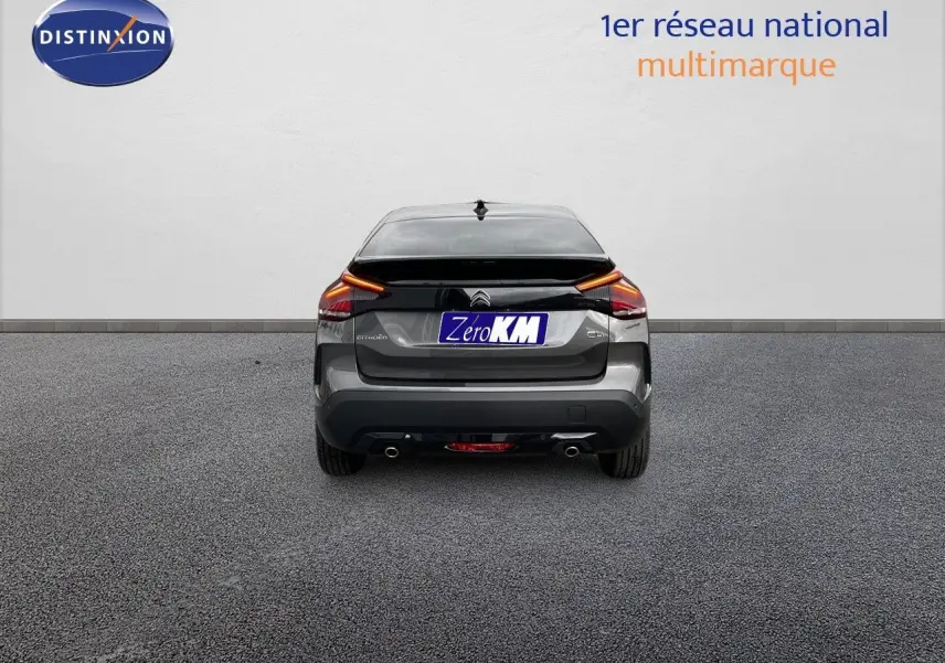 Vue arrière d'une Citroën C4 gris platinium métal 2024 avec feux LED et double sortie d'échappement visible.