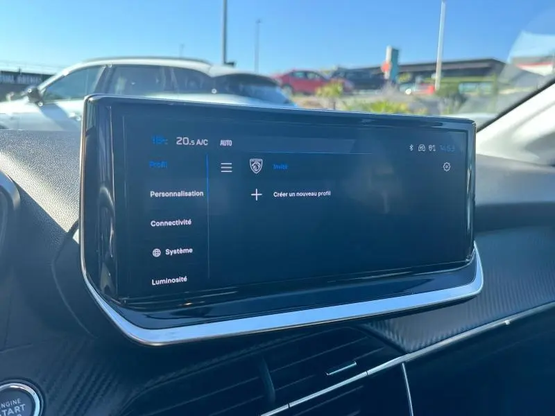 Écran tactile central du tableau de bord d'une Peugeot 208 1.2 100ch Allure 2024, intérieur moderne et épuré.