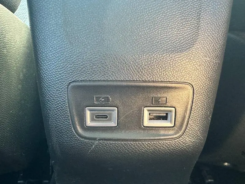 Prise USB-C et USB-A pour recharge, vue rapprochée sur la console arrière du Peugeot 208 gris 2024.