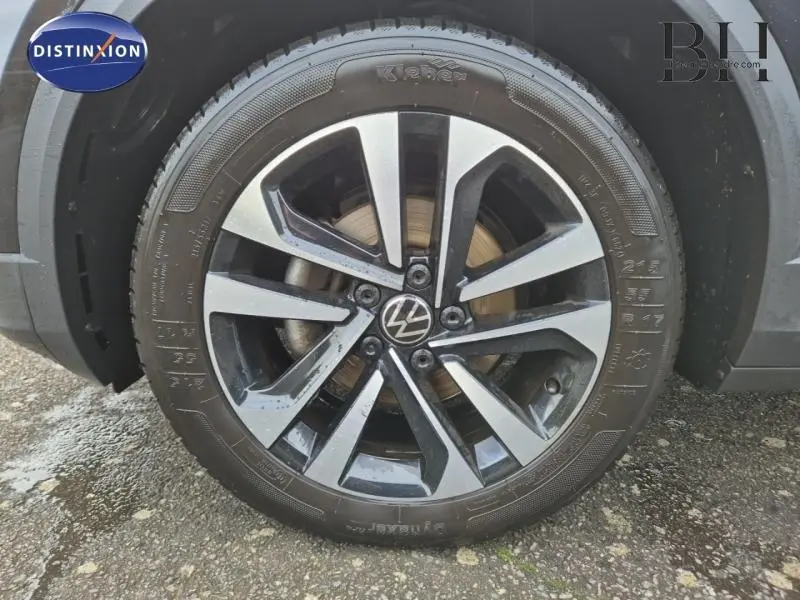 Gros plan sur la jante alu bicolore du côté gauche d'un Volkswagen T-Roc gris Urano 2021