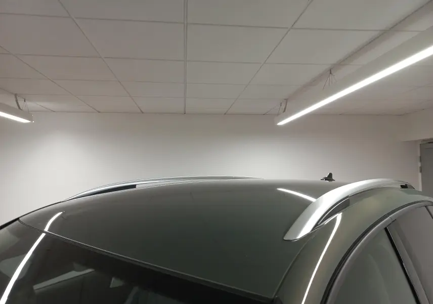 Toit panoramique noir brillant et barres de toit argentées sur un Volkswagen Tiguan Vert Cipressino, vue de dessus côté droit.