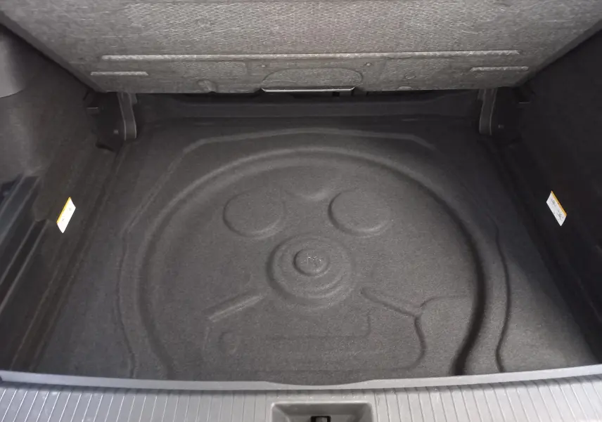 Coffre ouvert du Volkswagen Tiguan 2.0 TDI 150 DSG7 VW Edition 2025, vue intérieure sans roue de secours visible.