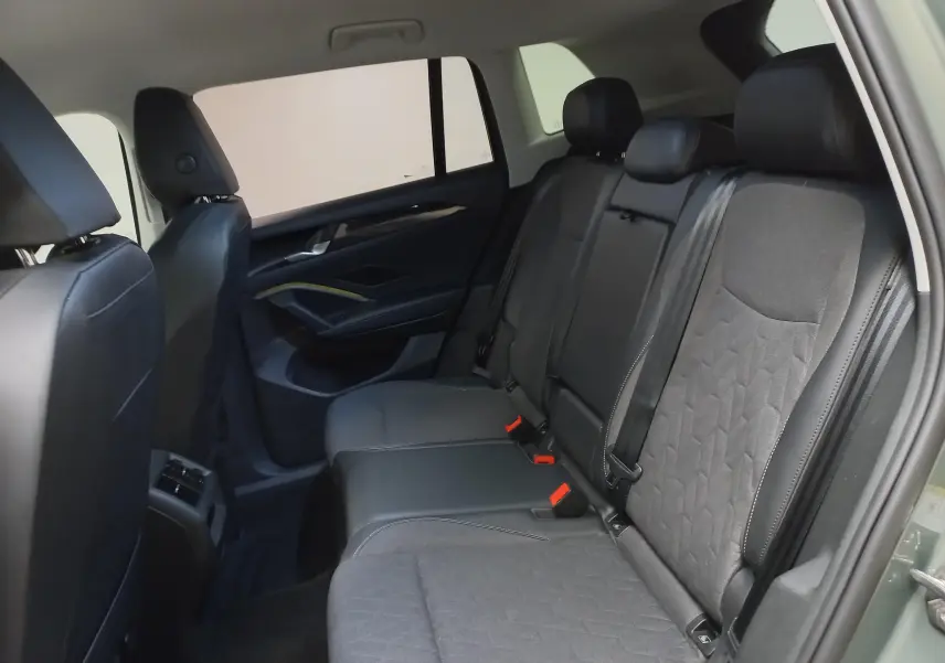 Vue intérieure arrière côté droit du Volkswagen Tiguan 2025 avec sièges en tissu noir et garnitures sombres.