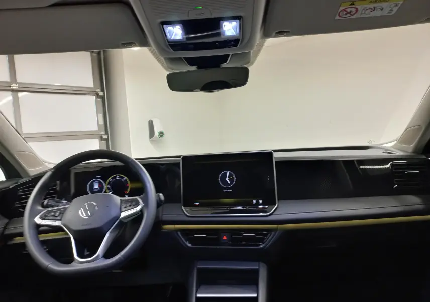 Vue intérieure avant du Volkswagen Tiguan 2025, tableau de bord moderne avec écran tactile et volant multifonction noir.