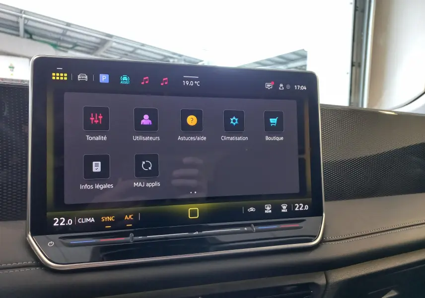 Écran tactile central du Volkswagen Tiguan 2025 affichant le menu des réglages, avec tableau de bord noir et finitions grises.