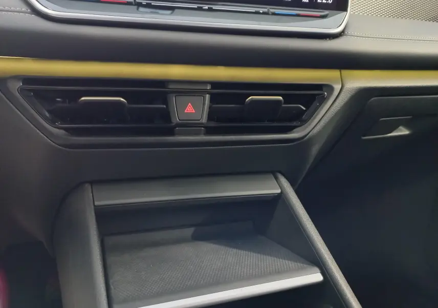 Détail de la console centrale du Volkswagen Tiguan 2025, avec boutons de signalisation d'urgence et aérateurs noirs.