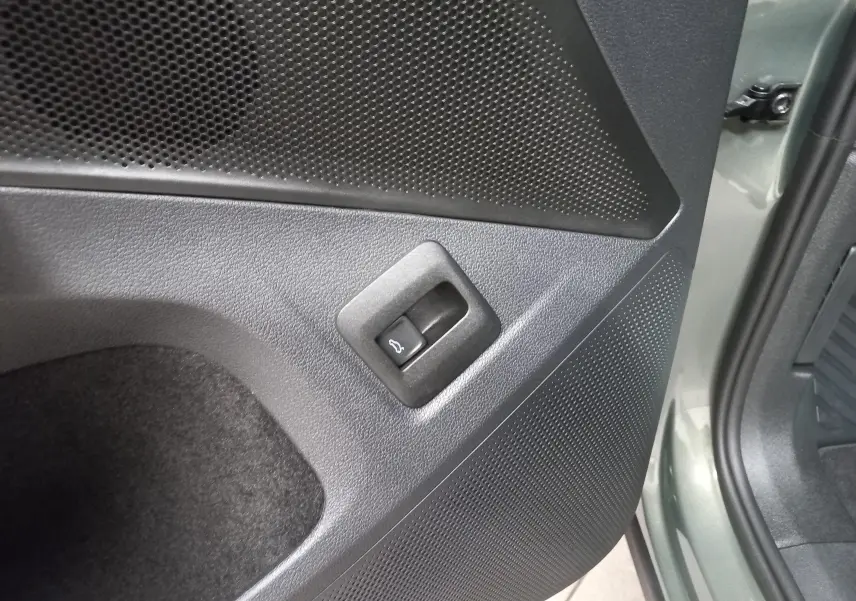 Détail de la portière arrière gauche du Volkswagen Tiguan Vert Cipressino avec bouton d'ouverture du coffre intégré.