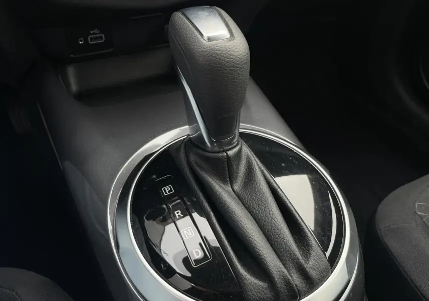 Le levier de vitesses automatique noir et argenté du Nissan Juke 2024 vu en gros plan dans l'habitacle.