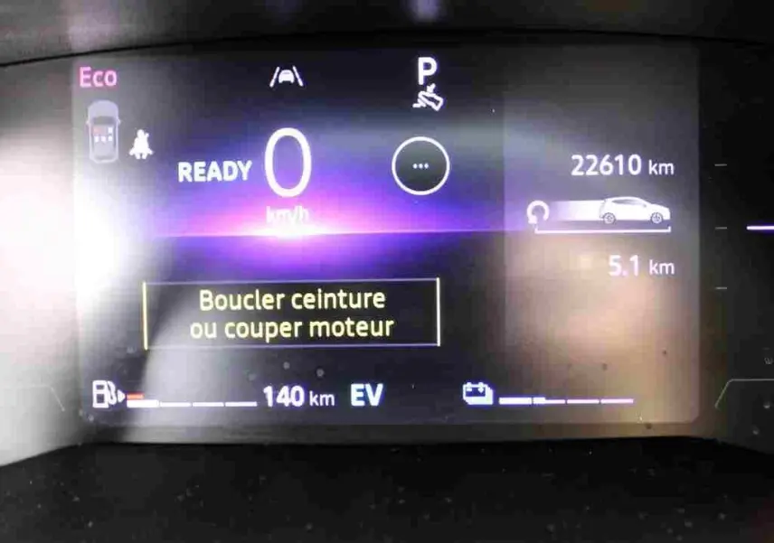 Affichage numérique du tableau de bord de la Renault Clio hybride, indiquant 0 km/h et un rappel de boucler la ceinture.