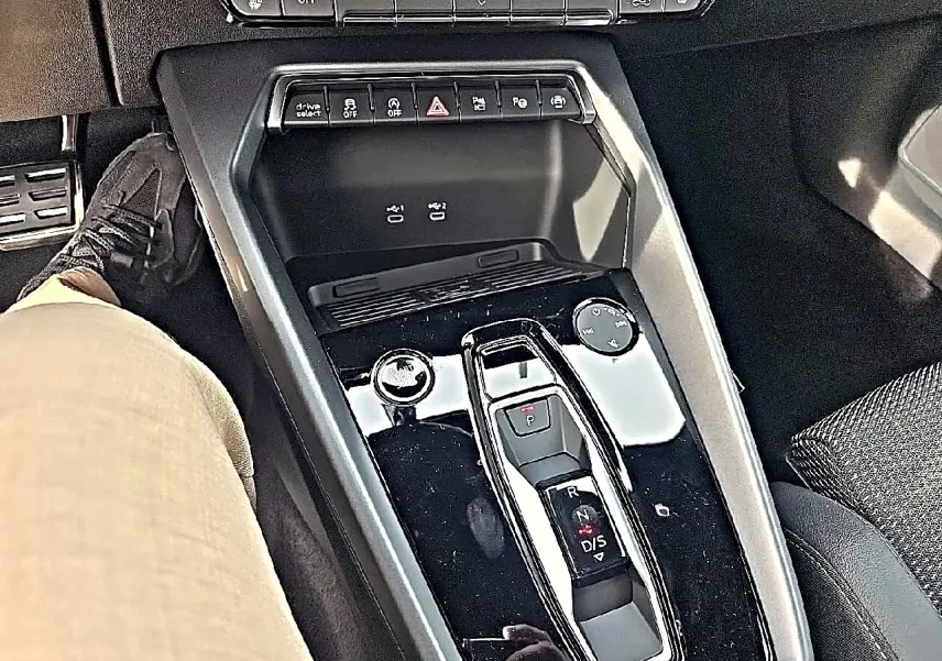 Vue plongeante sur la console centrale noire brillante avec levier de vitesses et commandes de l'Audi A3 Sportback 2026.