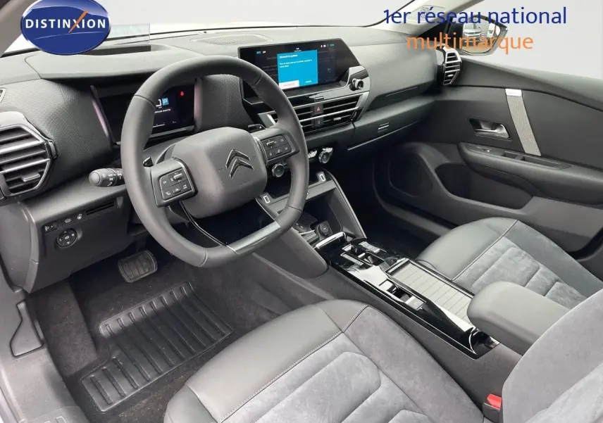 Intérieur moderne de la Citroën C4 2024, vue côté conducteur, avec volant multifonction et sièges cuir gris.