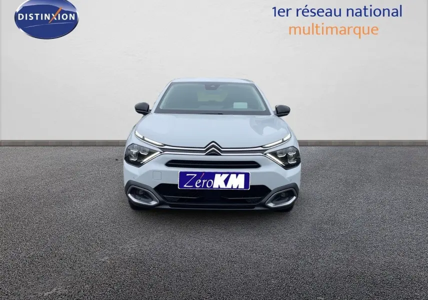 Vue frontale d'une Citroën C4 blanche métal 2024 avec feux LED et calandre distinctive, sur fond neutre.