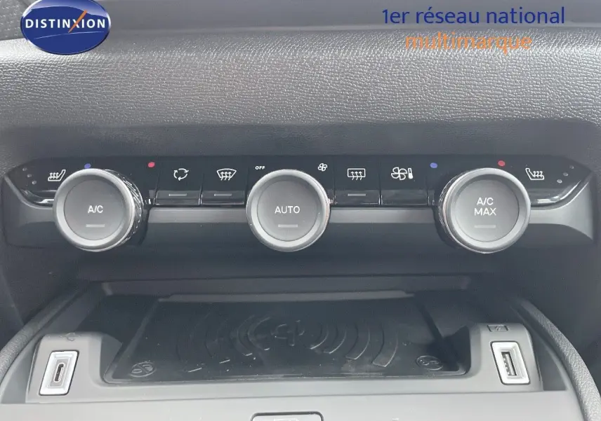 Panneau de commande de climatisation avec trois boutons ronds et ports USB dans l'habitacle d'une Citroën C4 blanche.