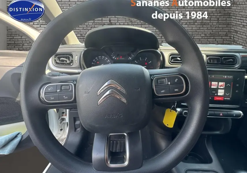Volant Citroën C3 2023 en vue frontale, avec commandes audio intégrées et tableau de bord numérique visible.