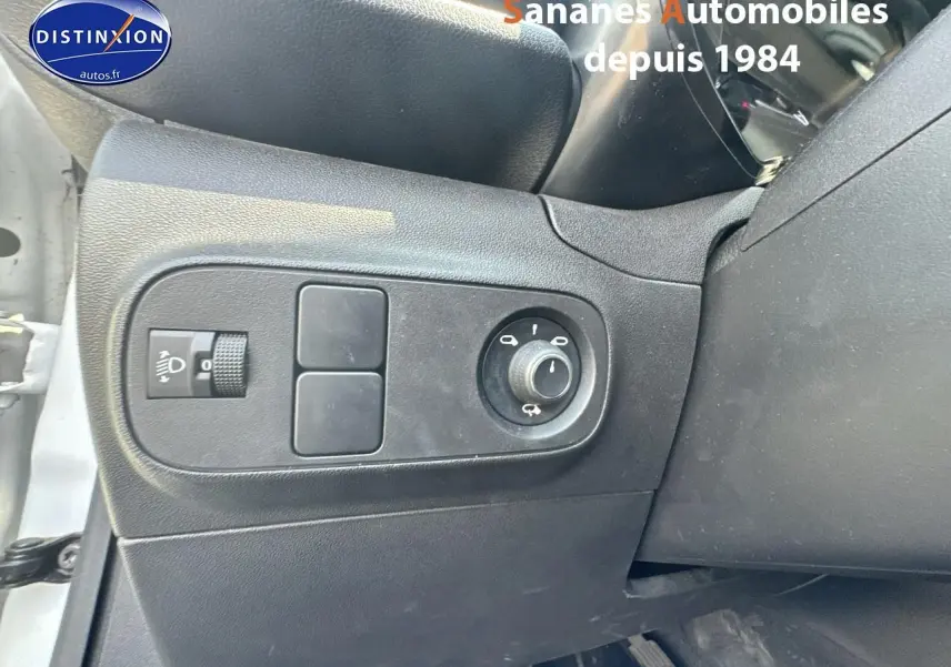 Gros plan sur les commandes d'éclairage et réglage des rétroviseurs côté gauche d'une Citroën C3 blanche 2023.